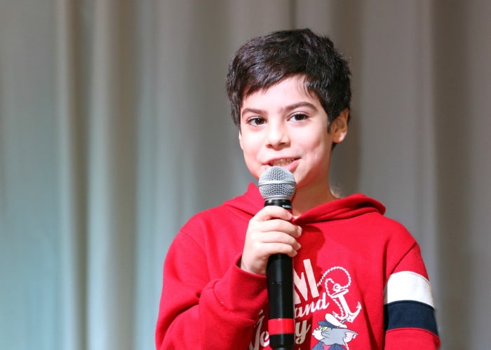 Niño con micrófono dando una charla